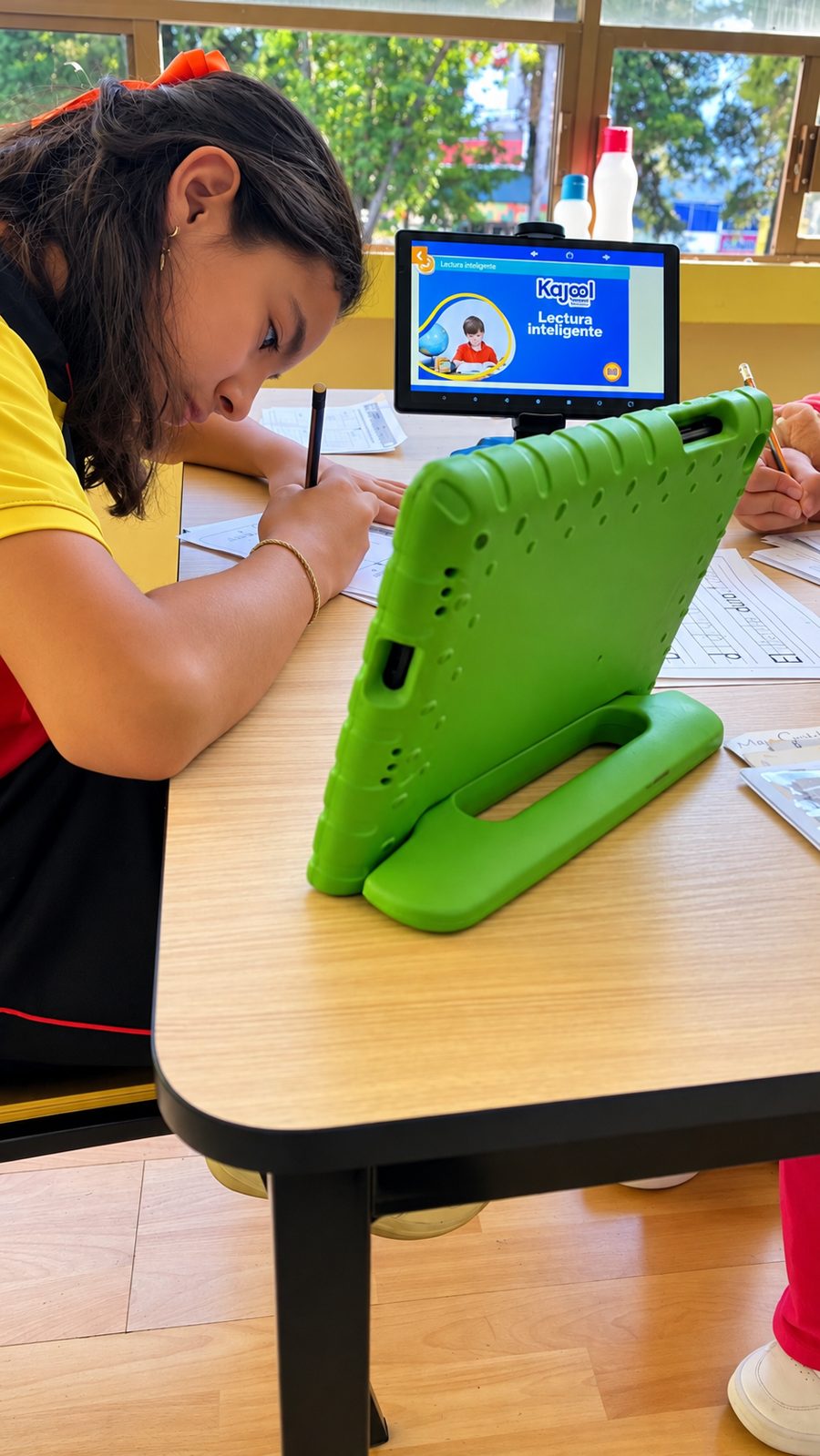 Alumna escribiendo junto a una tableta Kajool de Lectura interactiva